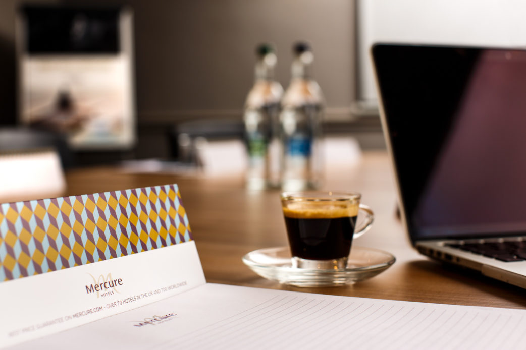 Meeting room table laptop and notepad at mercure hotels