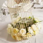 Close up of white bird cage with white flowers as table decoration