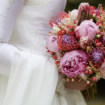bride in a white dress holding a colourful bouquet