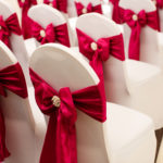 Close up of a dressed chair with a red ribbon prepared for a wedding at mercure hotels