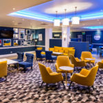 The lounge area at Mercure Swansea Hotel, yellow and blue velvet armchairs and sofas