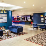 The lounge area at Mercure Swansea Hotel, yellow and blue velvet armchairs and sofas
