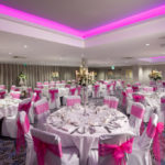Angled view of the lakeside suite set for a wedding with pink lighting at mercure gloucester bowden hall hotel